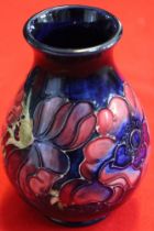 A Moorcroft pottery vase of baluster form, tube lined and painted Anemone design on a blue ground, 1