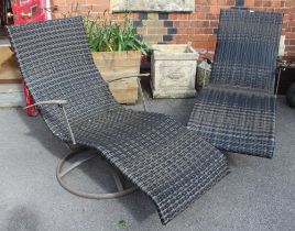 A pair of modern woven recliner sun chairs