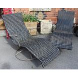 A pair of modern woven recliner sun chairs