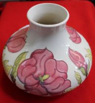 A Moorcroft pottery vase of squat form, pink magnolia design tube lined and painted on a cream groun