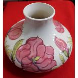 A Moorcroft pottery vase of squat form, pink magnolia design tube lined and painted on a cream groun
