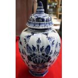 A hand painted Delft glazed earthenware vase of fluted form, having domed cover, cobalt blue floral