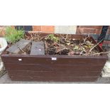 A rectangular wooden slatted garden planter