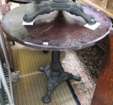 A cast iron tripod base wooden topped pub table 82 cm diameter top