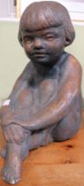 A patinated statue of a seated child, 31cm high (Vendor believes it has some past connection with th