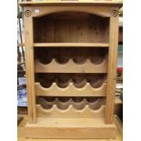 A pine open cupboard with shelf and wine racks below