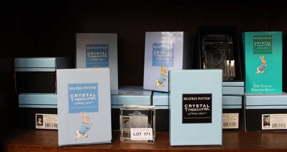 A shelf containing eleven boxed Beatrix Potter Crystal Treasures with a Snowman example