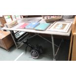 A wooden topped work table with tubular metal legs