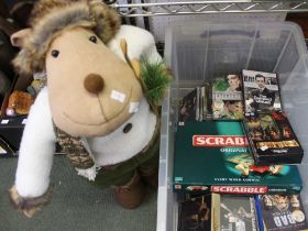 A large storage box containing a selection of CD's, DVD's and a plush Xmas reindeer