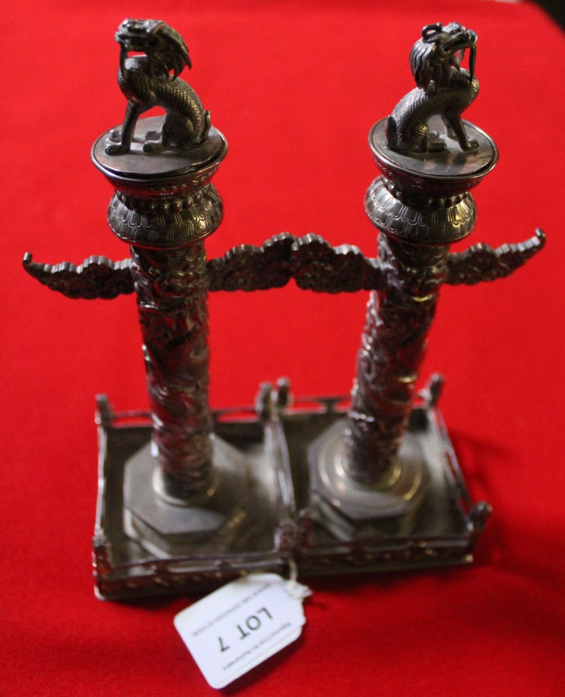 A pair of early 20th century Chinese silver candlesticks, totem column for, on square fenced bases,
