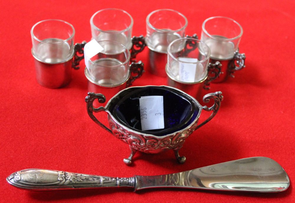 A set of six glass liquor tots in hallmarked silver holders, with cast flora handles, a hallmarked