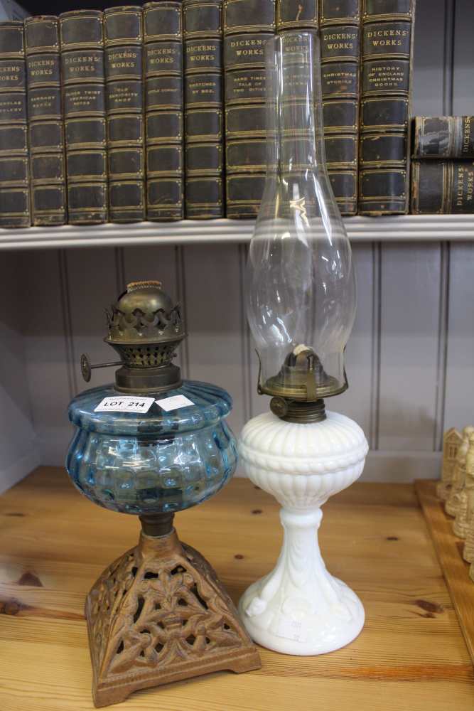Two Victorian oil lamps, one opaque glass base the other a cast metal base