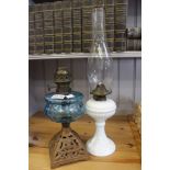 Two Victorian oil lamps, one opaque glass base the other a cast metal base