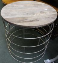 A modern circular metal framed table with a wooden top