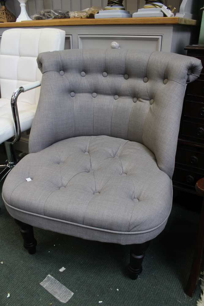 A modern grey upholstered button back easy chair