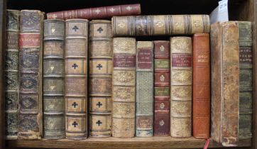 A shelf containing 14 leather bound decorative books with some hinges cracked and bindings worn