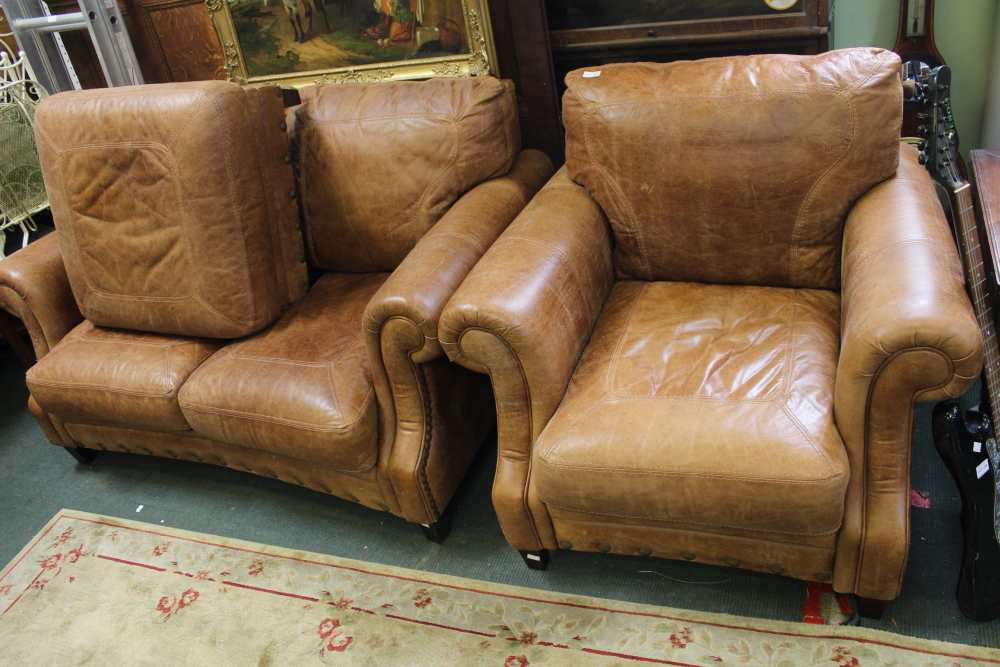 A well made brown leather two seater sofa together with an armchair & foot stool