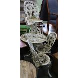 A well weathered cast metal garden table and four chairs