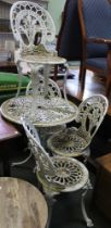 A well weathered cast metal garden table and four chairs
