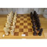A wooden chessboard together with resin set of chess pieces