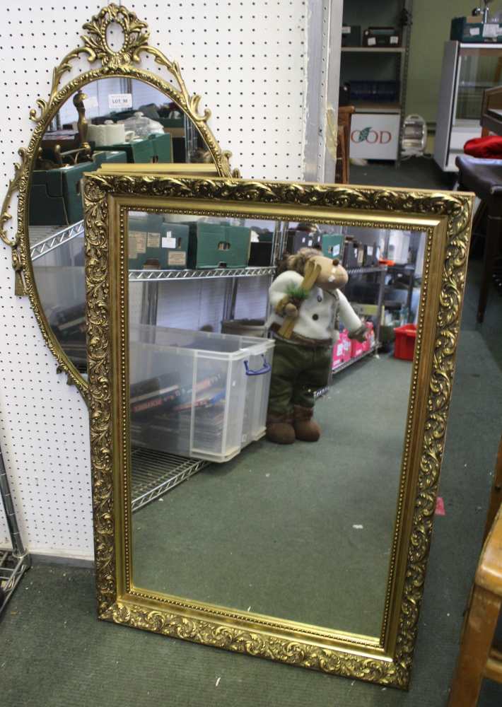 An oval metal gilt wall mirror, and a rectangular gilt framed wall mirror