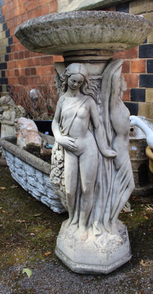A cast garden bird bath with classical figures to base