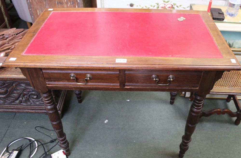 A mahogany two drawer writing desk with red skiver insert top