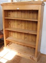 A rustic pine bookcase with four shelves