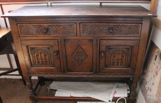 An Old Charm style sideboard with 2 drawers over 2 cupboard doors with carved front
