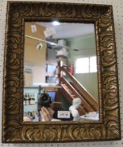 A vintage wooden carved frame and gilded wall mirror