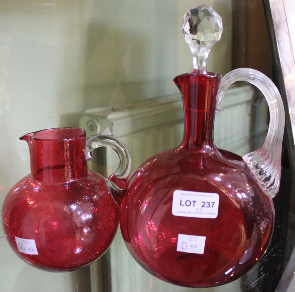 A 19th century cranberry glass jug decanter, with facet cut stopper, together with a crazed ware cra