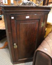 A 19th century oak corner cupboard with brass butterfly hinges