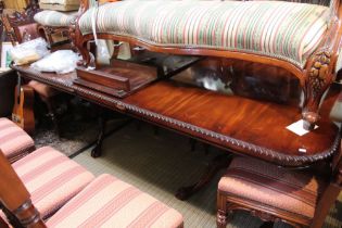 A large twin pedestal reproduction hardwood fancy edged dining table with two leaves
