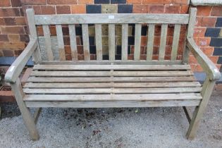 A two seater slatted wooden garden bench