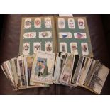 A cigarette card album together with a quantity of early 20th century postcards