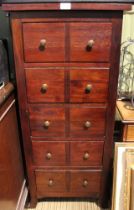 A tall slender hardwood chest of five drawers