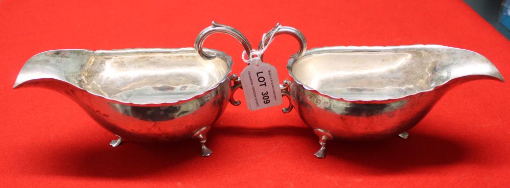 A pair of late 19th century silver gravy boats, having 'C' scroll handles, on trefid feet, hallmarks