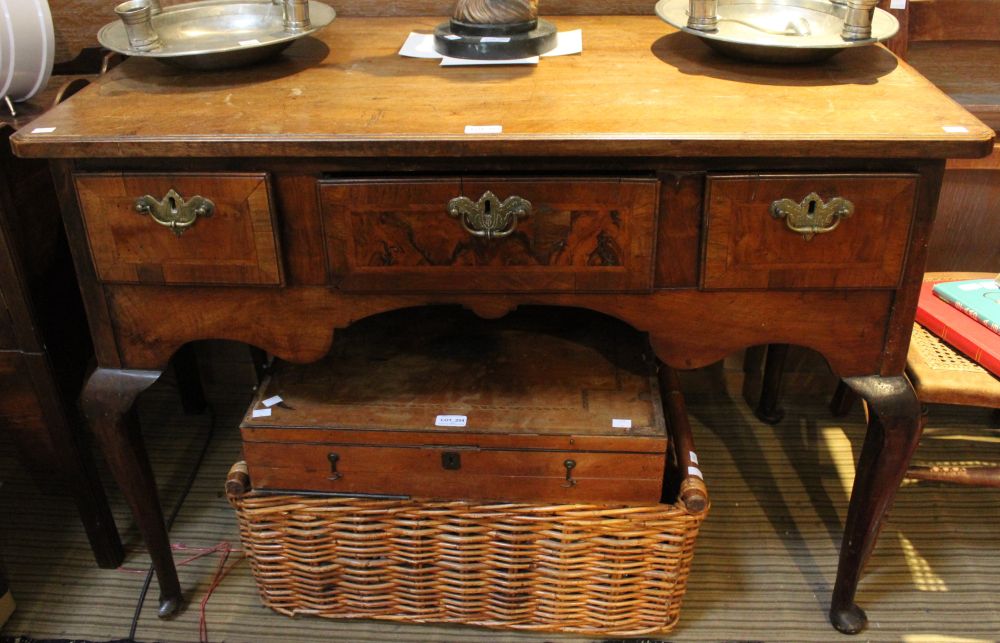 A mahogany veneered three drawer low boy on cabriole legs