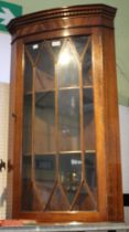 A reproduction mahogany corner cupboard with glazed door