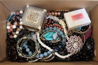 A shoebox containing a selection of costume jewellery