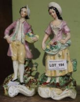 A pair of 19th century Staffordshire pottery figures, gardeners in 18th century costume, in the mann