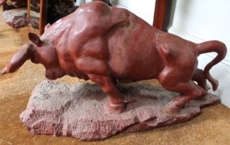 A pair of red painted cast iron charging bulls