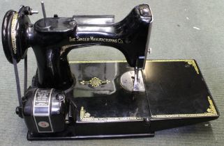 A vintage Singer sewing machine in original carry box with accessories