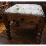 A small carved oak footstool with bobbin turned legs and upholstered top