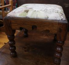 A small carved oak footstool with bobbin turned legs and upholstered top