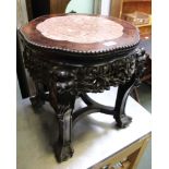 A highly carved mahogany Oriental style table with marble inset top