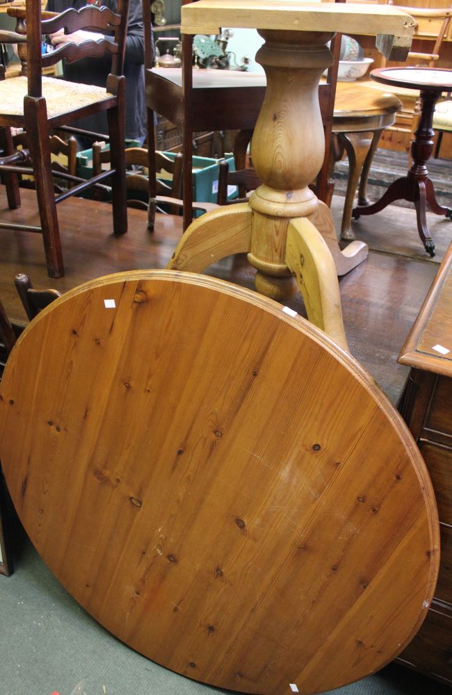 A rustic pine circular kitchen table on tripod base