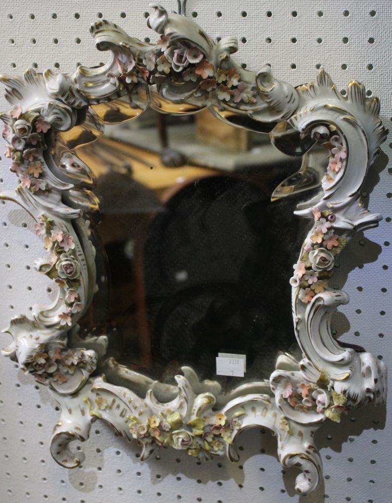 A porcelain framed mirror, in the Rococo taste, having polished wood back, overall size 39cm x 32cm
