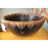 A large vintage lightwood African bowl with wicker binding to the rim