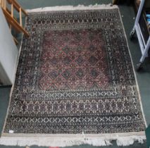 A cream ground floor rug with centre panel and geometric pattern in blue and red